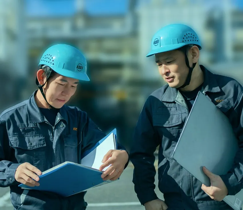 ヘルメットを着用した2人の作業員が真剣に話し合っている様子